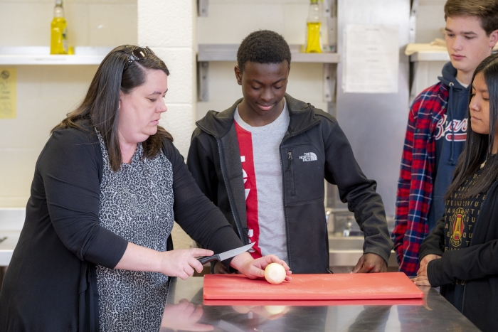 An instructor teaches about a proper food handling method.