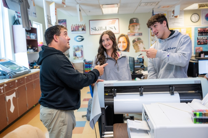 Students work with a teacher.