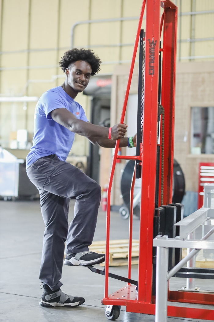 A student poses in a warehouse.