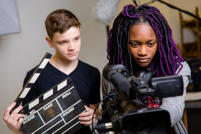 Two students work on video production.