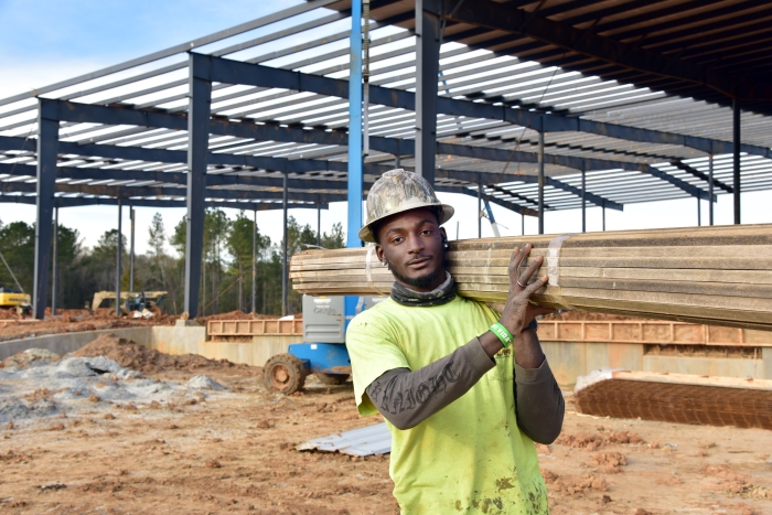 A student holds lumber.